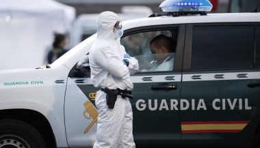 Agent în costum de protecție biohazard lângă un vehicul Guardia Civil, în cadrul operațiunilor de carantină legate de focarul de hantavirus de pe nava MV Hondius. Foto ilustrativ.