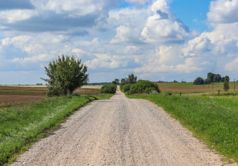 Drum neasfaltat de piatră și pietriș dintr-o zonă rezidențială, simbol al infrastructurii lipsă din multe orașe din România. Foto ilustrativ.