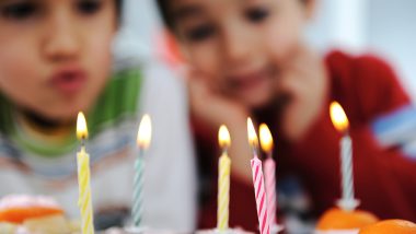 Doi copii mici privesc lumânările unui tort de ziua de naștere, simbol al natalității în scădere în Europa